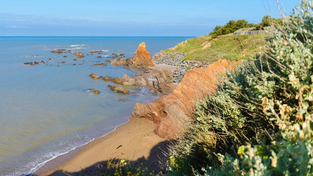 A coastal landscape with a sandy beach, rocky outcrops, and a clear blue sky. - Air Marin - Apartment Balcony Ocean View (Saint-Hilaire-de-Riez)