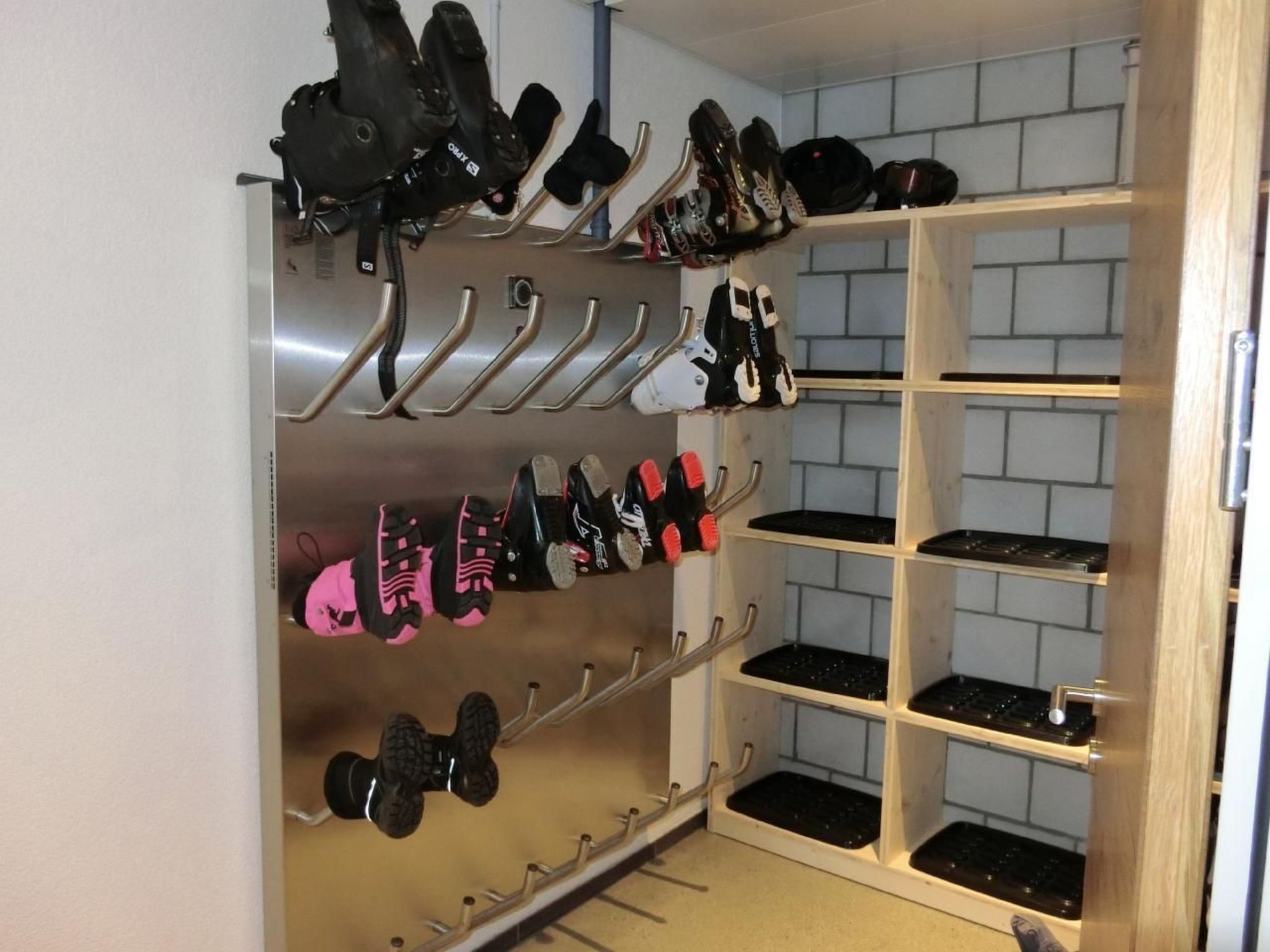 Een schoenenrek met verschillende paar rollerskates en een houten plankunit met zwarte bakken.