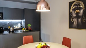 A modern kitchen with a copper pendant light, a dining table with a bowl of fruit, and a framed artwork on the wall. - Cicerone Wohnung by Interhome (Bergamo)