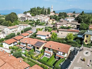 A residential area with terracotta-roofed houses, a central square, and a church with a bell tower. - FeWo C-15A by Interhome (Colà)
