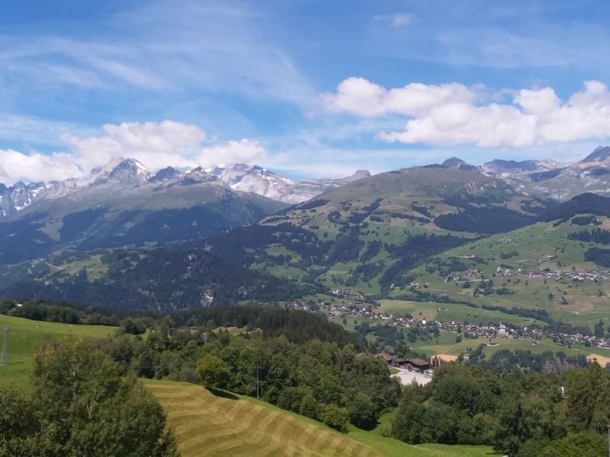 Un paisaje montañoso con un pequeño pueblo en el valle.