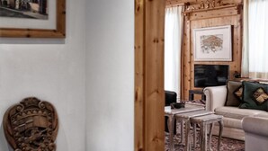 A cozy living room with a wooden ceiling, a sofa, a coffee table, and a framed picture on the wall. - Luxus Alpenchalet Brigitta I by Interhome (Arosa)