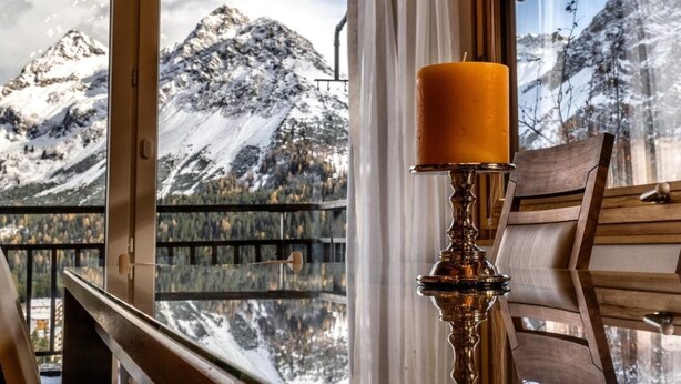 A room with a large window offering a view of snow-capped mountains and a lake. - Luxus Alpenchalet Brigitta I by Interhome (Arosa)