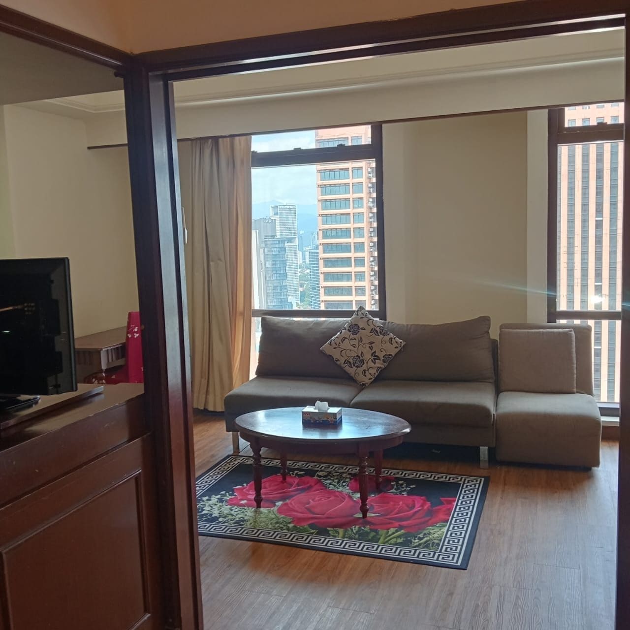 A living room with a sofa, a coffee table, and a television.