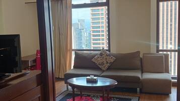 A living room with a sofa, a coffee table, and a television.