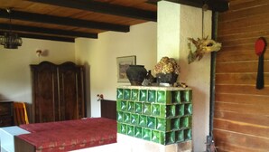 Um quarto com uma cama, uma lareira com azulejos verdes, mobiliário de madeira e decoração rústica.