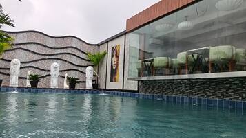 Une piscine agrémentée d’un mur décoratif et d’un espace détente offrant une vue sur la piscine.