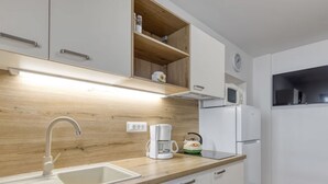 A modern kitchen with a wooden countertop, white cabinets, a built-in sink, a coffee maker, and a microwave. - Wohnung 'Silva5' mit Wasserblick by Interhome (Rovinj)