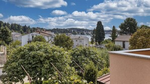 A residential area with houses, trees, and a clear blue sky with clouds. - Wohnung 'Silva5' mit Wasserblick by Interhome (Rovinj)