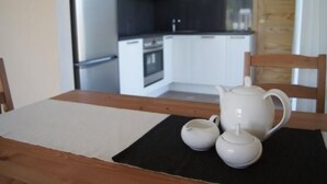 Eine Küche mit weißen Schränken, einer schwarzen Arbeitsplatte und einer Uhr an der Wand.
