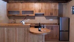 Eine Küche mit Holzschränken, einem Edelstahlkühlschrank und einer Holztresenplatte.