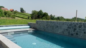 Ein Schwimmbecken mit Steinwänden und glasklarer Wasserfläche.
