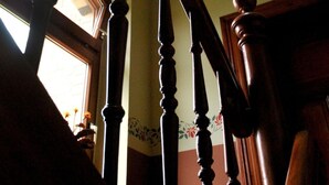 Una escalera de madera con barandilla y una ventana en la parte superior.