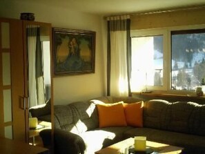 Ein Wohnzimmer mit einer Couch, einem kleinen Tisch und einem Bild an der Wand.