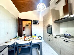 Een koelkast, een magnetron, een oven, kookgerei, borden en bestek