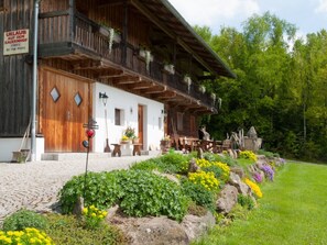 En traditionell träbyggnad med en balkong, en skylt som visar att det finns en bastu och en välkomnande skylt.