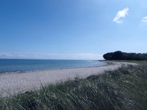 A beach with a clear sky and calm sea.