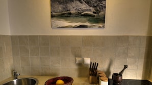 A kitchen with a sink, a basket of lemons, a knife block, and a stove. - Istrien Traditionelles Steinhaus 7 by Interhome (Buzet)