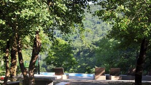 A campsite with picnic tables and chairs, surrounded by trees and a view of a forested area. - Istrien Traditionelles Steinhaus 6 by Interhome (Buzet)