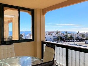 A balcony with a view of a coastal town and parked cars. - Apartment in Nerja Near Carabeo Beach (Nerja)
