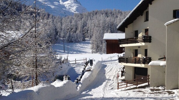 A snow-covered mountain with a chalet-style building in the foreground. - Apartment  by Interhome (Celerina)