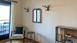 A room with a chair, a small table, a mirror, and a bookshelf. - Residenza Viramonte - Casa Bianca, Wohnung 14 by Interhome (Vira)