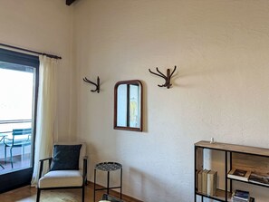 A room with a chair, a small table, a mirror, and a bookshelf. - Residenza Viramonte - Casa Bianca, Wohnung 14 by Interhome (Vira)