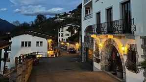A street with buildings, including a white building with balconies and a stone archway. - Residenza Viramonte - Casa Bianca, Wohnung 14 by Interhome (Vira)