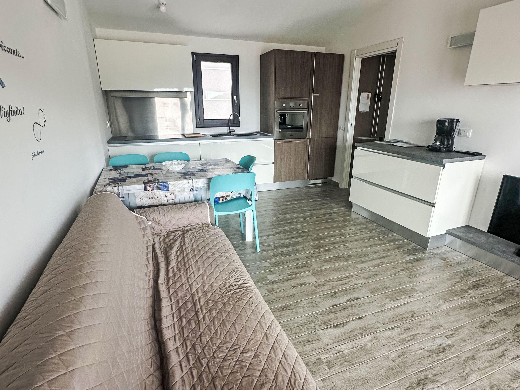 A compact living space with a kitchenette, a dining area, and a sofa.