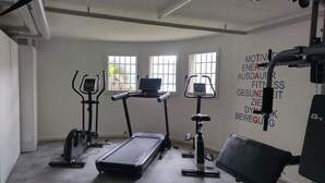 Une salle de sport équipée de tapis de course, de vélos elliptiques et de matériel de musculation.