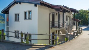 Ein zweistöckiges Gebäude mit Balkon, Treppe und Blick auf die umliegende Landschaft.
