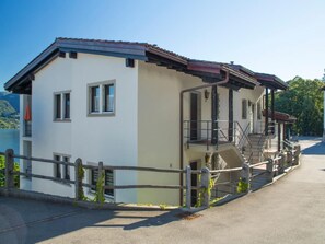 Ein zweistöckiges Gebäude mit Balkon, Treppe und Blick auf die umliegende Landschaft.