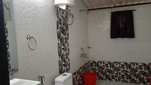 A bathroom with a white sink, toilet, and shower area. - MARS Resort (Shahapur)