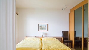 A bedroom with a bed, a desk, a chair, and a picture on the wall. - Residenza Viramonte - Casa Aurelia, Wohnung 8 by Interhome (Vira)
