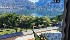 A balcony with a table and chairs, overlooking a lake with mountains in the background. - Residenza Viramonte - Casa Aurelia, Wohnung 8 by Interhome (Vira)