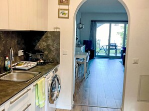 Une cuisine moderne équipée d’un lave-linge, d’un évier et d’un coin repas avec vue.
