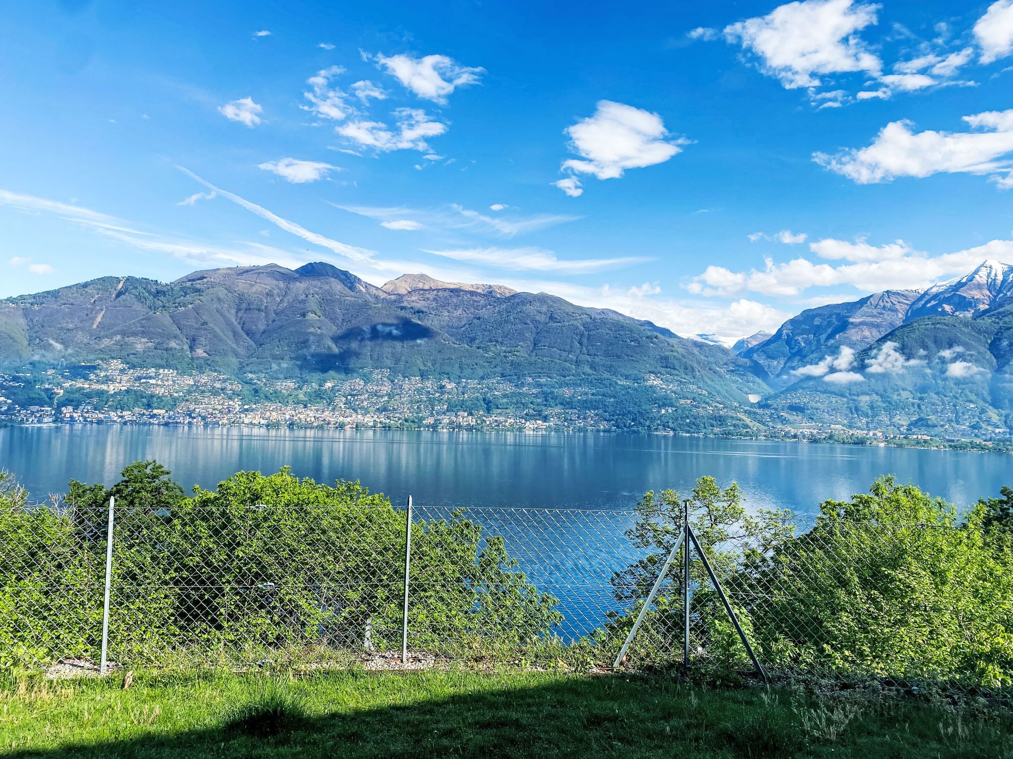 Un paysage montagneux avec un lac et une ville située dans la vallée.