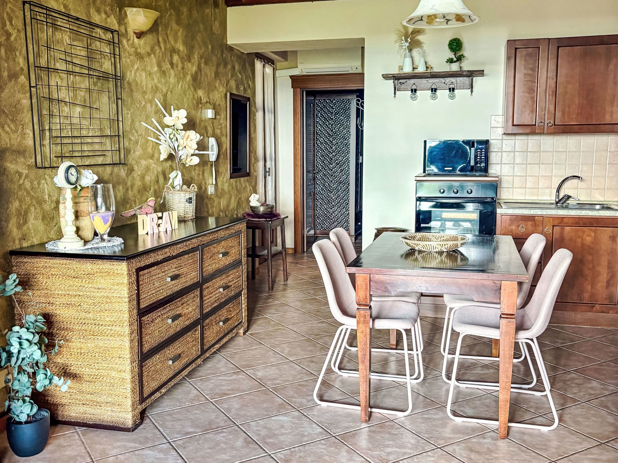 A kitchen with a dining table, chairs, a stove, and a decorative wall.