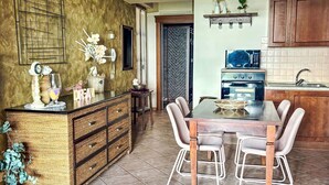 Una cucina con un tavolo da pranzo, sedie, un fornello e una parete decorativa.