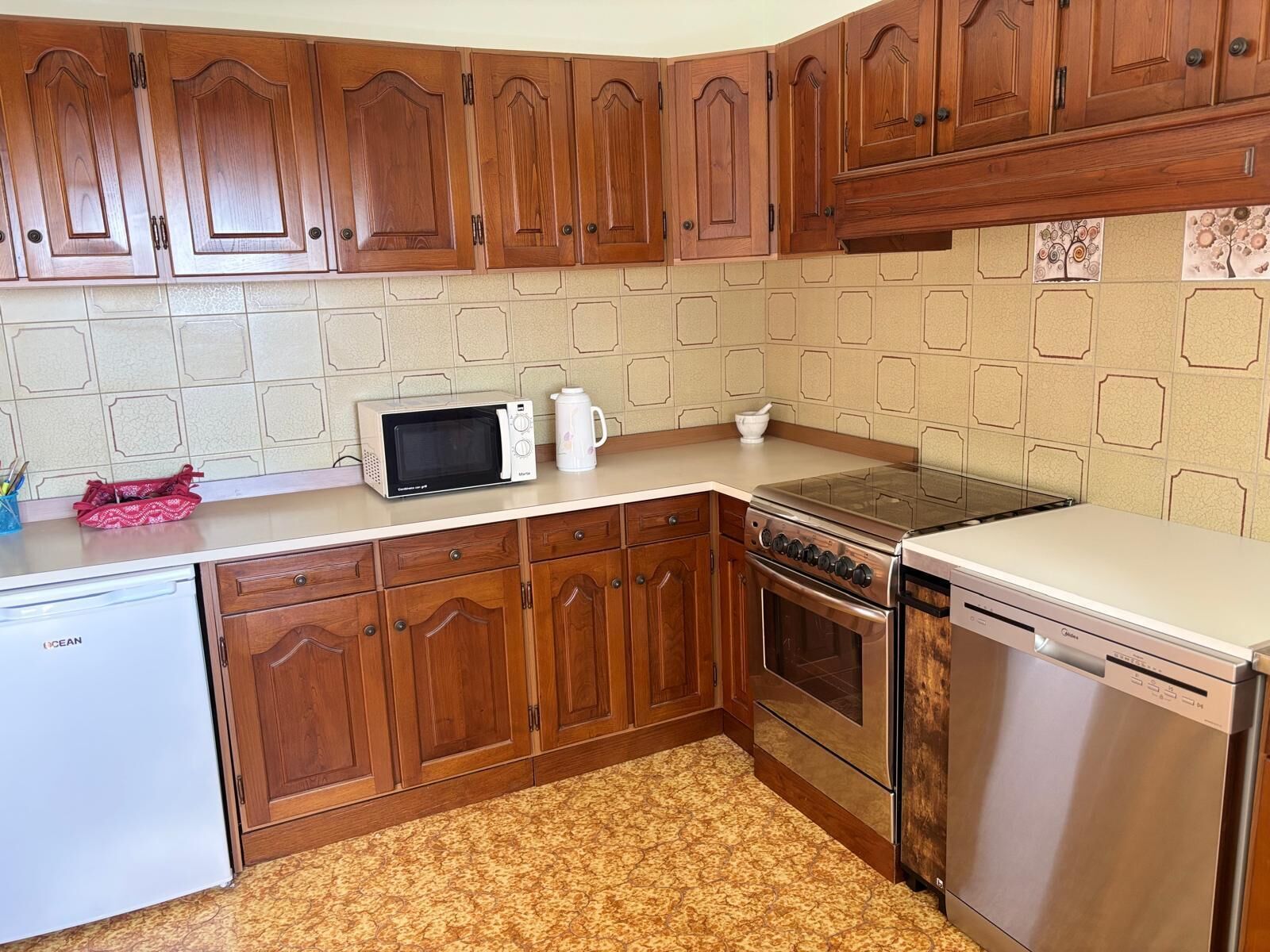 A kitchen with wooden cabinets, a microwave, a stove, and a dishwasher.