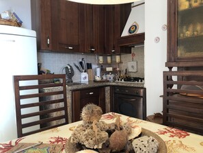 Geladeira, fogão, talheres/pratos/utensílios de cozinha