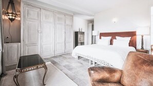 A bedroom with a large bed, a chest of drawers, a small table, and a lamp. - Gîte in the heart of the vineyards (Larroque)