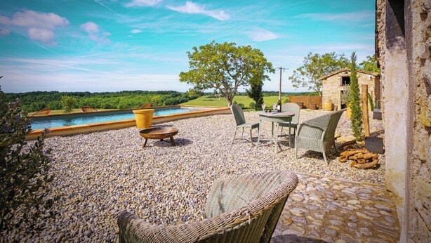 A patio with outdoor furniture, a swimming pool, and a stone wall. - Gîte in the heart of the vineyards (Larroque)