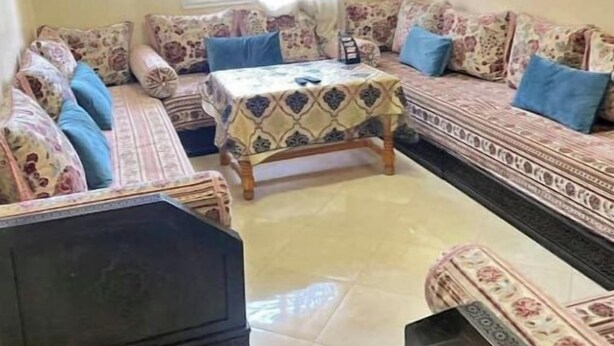 Una sala de estar con un sofá, una mesa de centro y un televisor.