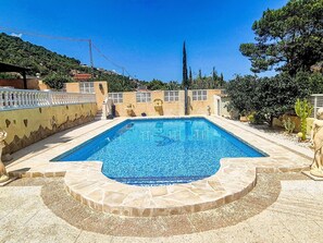 A rectangular swimming pool with a tiled edge, surrounded by a stone deck and a low wall. - Casa Flamingo by Interhome (Calpe/Calp)