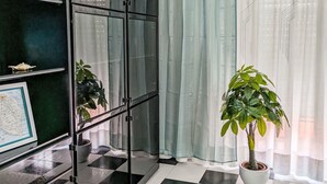 Una habitación con piso a cuadros, un aparador de vidrio, un mapa en la pared y una planta en maceta.