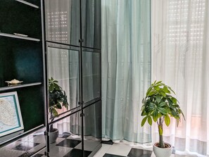 A room with a checkered floor, a glass cabinet, a map on the wall, and a potted plant. - Giotto Aradeo by Interhome (Acquarica del Capo)