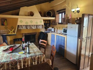 Een koelkast, een microgolfoven, een oven, kookgerei, borden en bestek