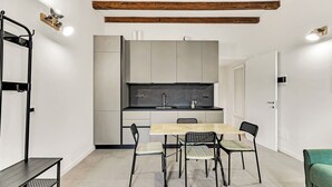 Egy modern konyha, központi szigettel, étkezőasztallal és hozzáillő székekkel, valamint egy padkával.