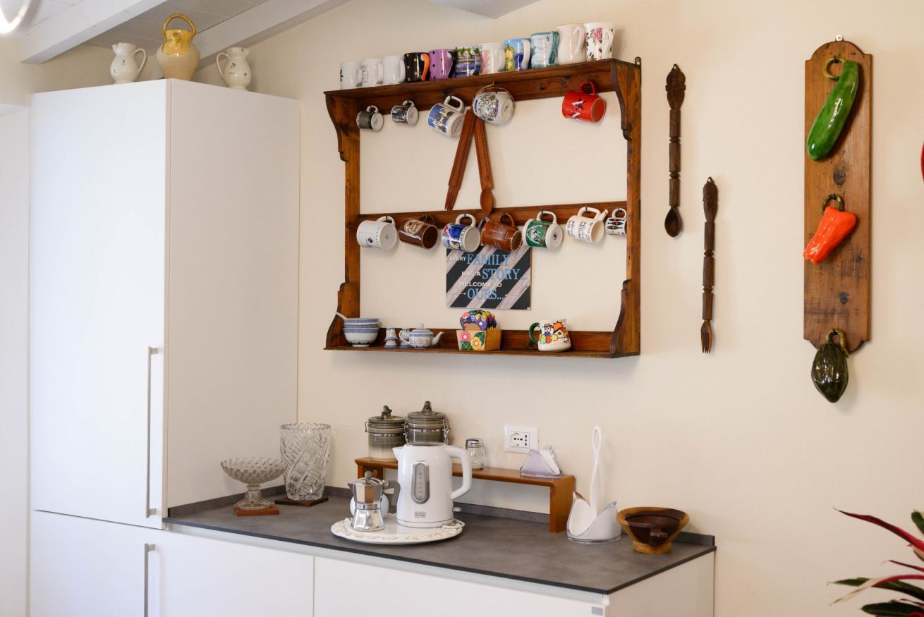 Eine Küche mit einem Holzmugthalter, einer Kaffeemaschine und verschiedenen Küchenutensilien.